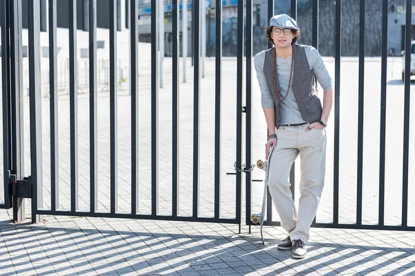 Ragazzo piacevole alla moda è appoggiato sulla recinzione — Foto Stock