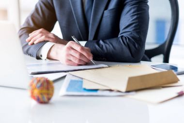 Takım elbiseli genç adam ofisinde çalışıyor