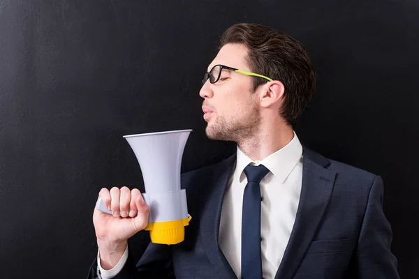 Elegante hombre de traje está de pie con megáfono —  Fotos de Stock