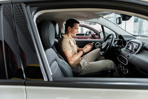 Macho de saída assistindo no telefone no carro — Fotografia de Stock