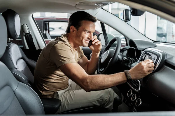 Hombre sonriente hablando por teléfono en el coche — Foto de Stock