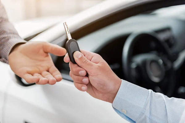 Agente mão dando a chave do carro para o cliente — Fotografia de Stock