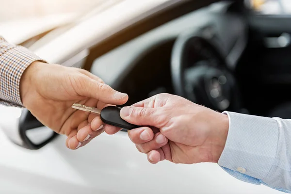 Buyer arm taking automobile clef from salesman — Stock Photo, Image