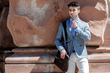 Kendine güvenen ciddi adam tutarak el çantası