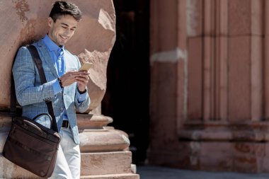 Neşeli gülümseyen adam telefonda yazarak