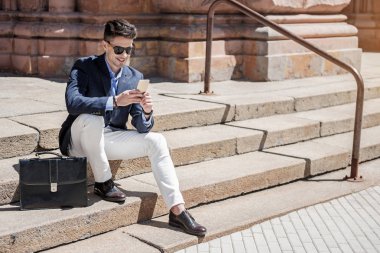 Akıllı telefon kullanan neşeli erkek kişi