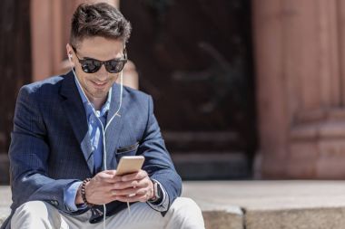 Telefonda yazarak neşeli gülümseyen iş adamı