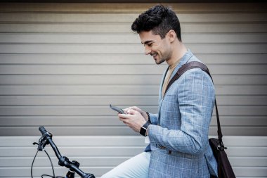 Neşeli gülümseyen erkek kişi Smartphone'da yazarak