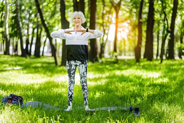Счастливая пожилая стройная женщина, тренирующаяся снаружи — стоковое фото