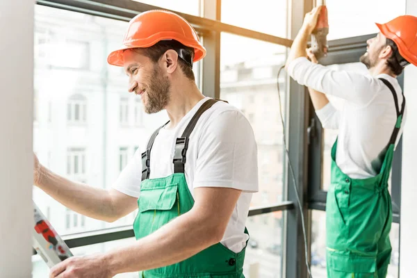 Felices constructores sonrientes trabajando juntos — Foto de Stock