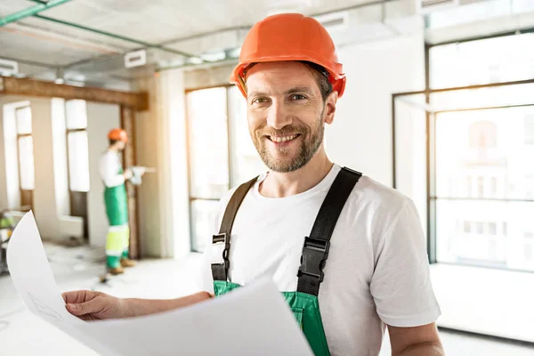 Alegre constructor sonriente manteniendo corrientes de aire —  Fotos de Stock