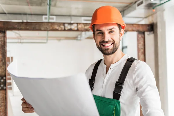 Hilarante constructor sonriente manteniendo documento — Foto de Stock