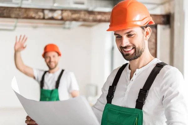 Alegre constructor sonriente mantener el plan —  Fotos de Stock