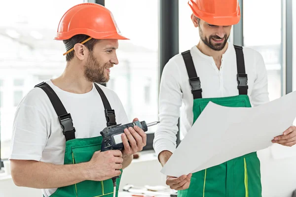 Constructeurs souriants occupés faisant leur travail — Photo