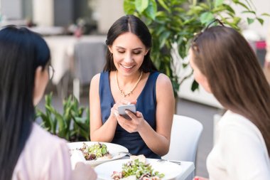 Mutlu kadın telefonu kafede, izlerken