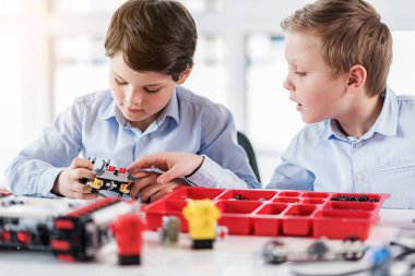 İlgilenen çocuk küçük robot bakıyor