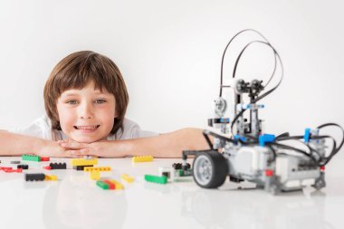 Robot bakarak gülümseyen erkek çocuk