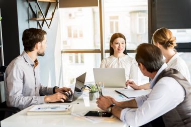 Kendine güvenen neşeli çalışanları ofiste fikir paylaşımı