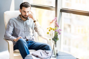 Şık ciddi tıraşsız adam RECLINER içinde dinlenme