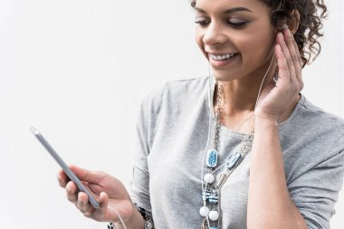 Neşeli genç bayan smartphone ile açık havada duruyor