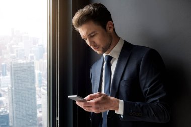 Ciddi şık adam kötü smartphone kullanarak haber okuma