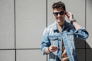 Mutlu gülümseyen erkek kişi kulaklık kullanarak