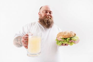 Alkol içecek sandviçle mutlu şişman adam yeme