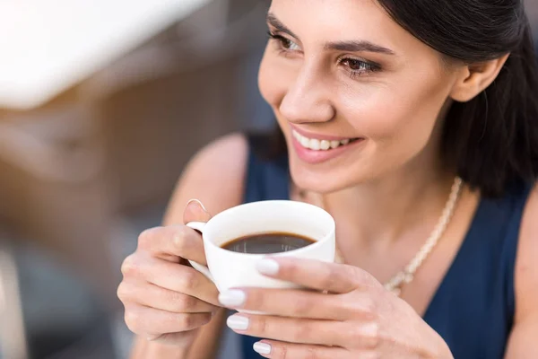 Beaming girl drinking cup of coffee — Stock Photo, Image