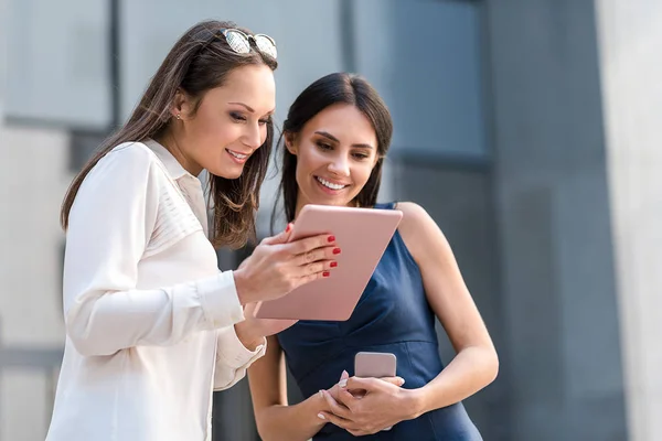 Chicas alegres viendo en el dispositivo digital — Foto de Stock