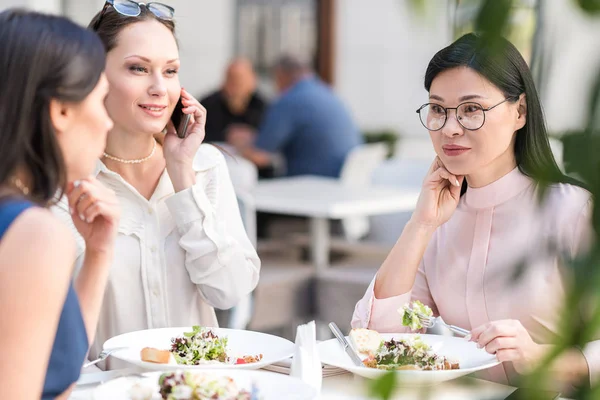 Nadenkend vrouwelijke eten schotel in café — Stockfoto