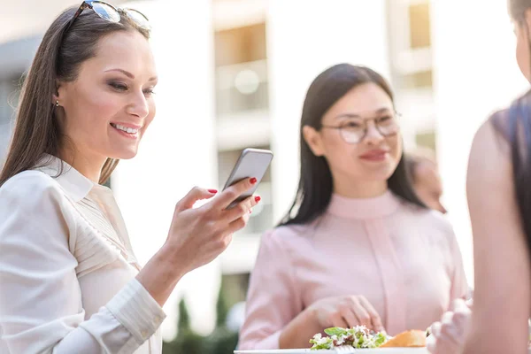 Sugárzó nő néz telefon kávézó — Stock Fotó