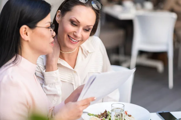 Cheerful woman watching at document in cafe — Stock Photo, Image