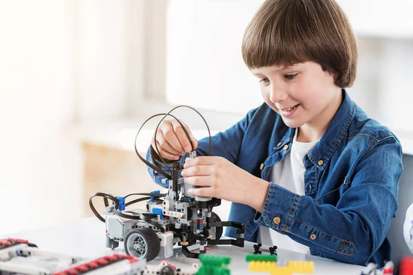 Felice sorridente ragazzo costruisce giocattolo tecnico — Foto Stock