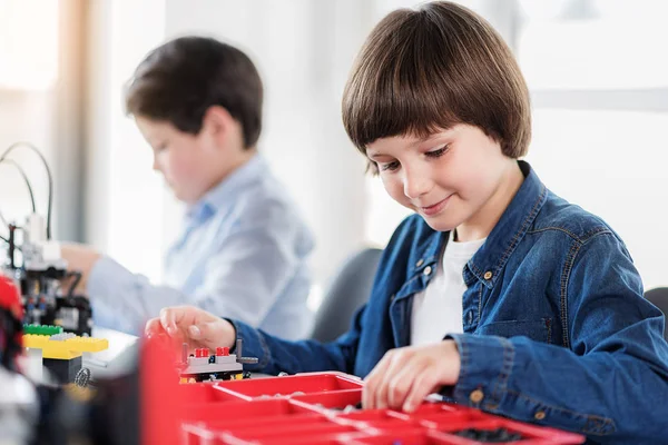 Joyeux enfant souriant intéressé faisant jouet — Photo