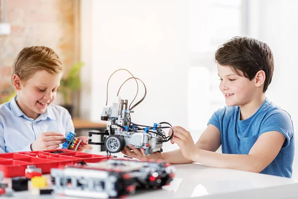 Heureux jeunes techniciens souriants faisant des jouets — Photo