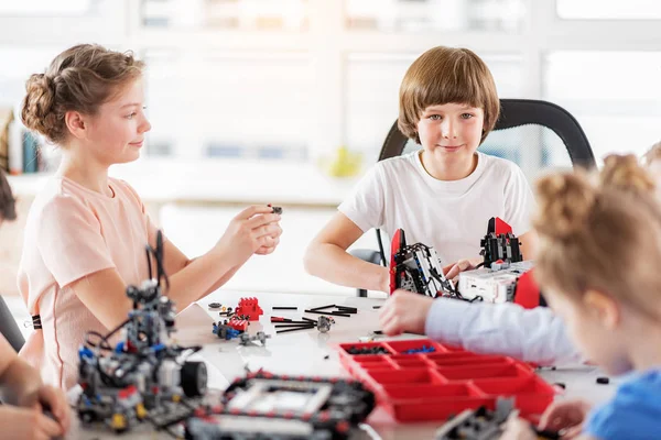 Curiosos niños sonrientes haciendo juguetes técnicos — Foto de Stock