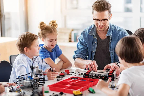 Joyeux constructeur souriant vérifier jouet technique — Photo