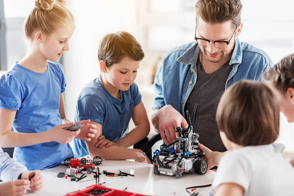 Personnes souriantes intéressées à créer un robot — Photo