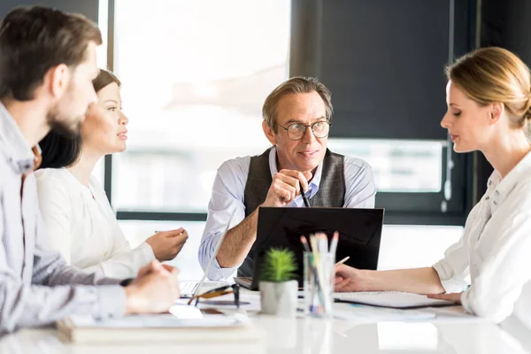 Equipo de éxito concentrado sentado en la mesa — Foto de Stock