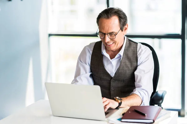 Positive mature male working on notebook — Stock Photo, Image