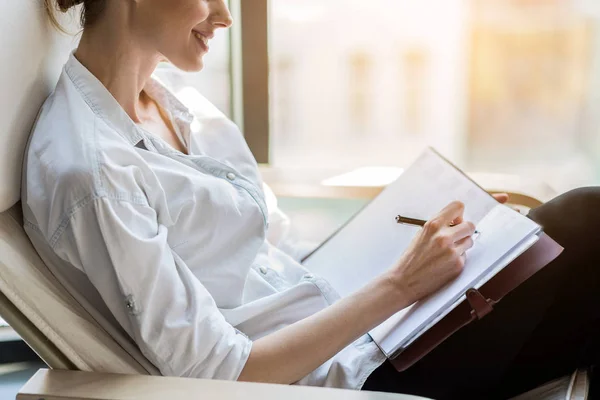 Vrolijke elegante vrouw het neerschrijven van commentaar in tijdschrift — Stockfoto