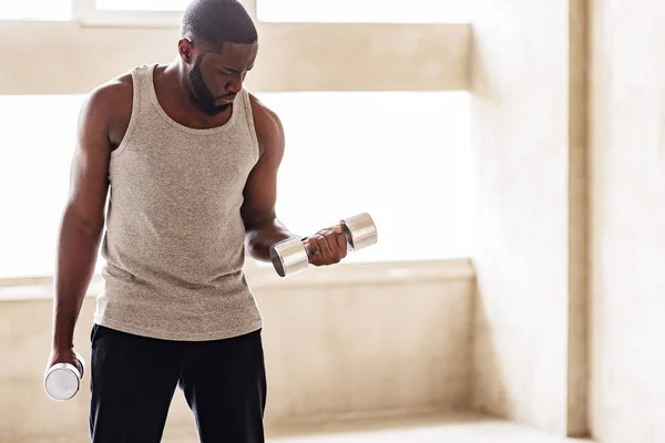 Severe african bearded sporty guy making power exercises