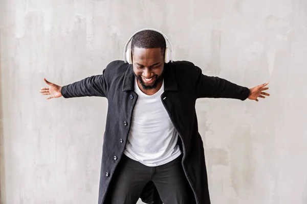 Jolly knappe Afrikaanse man met baard genieten van zijn geliefde nummers via oortelefoons — Stockfoto