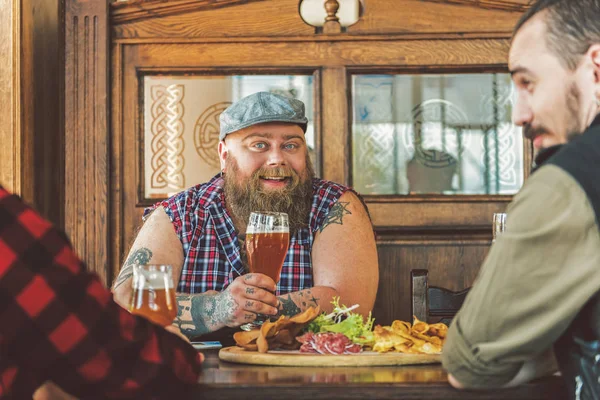 Приятные веселые мужчины проводят время вместе в баре — стоковое фото