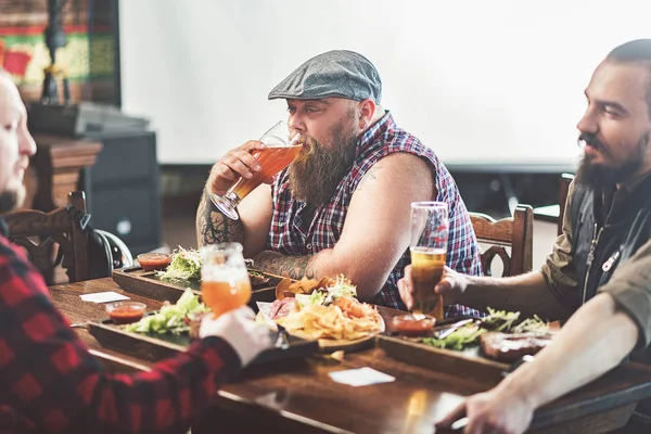 Drie volwassen mannetjes pils drinken in pub — Stockfoto