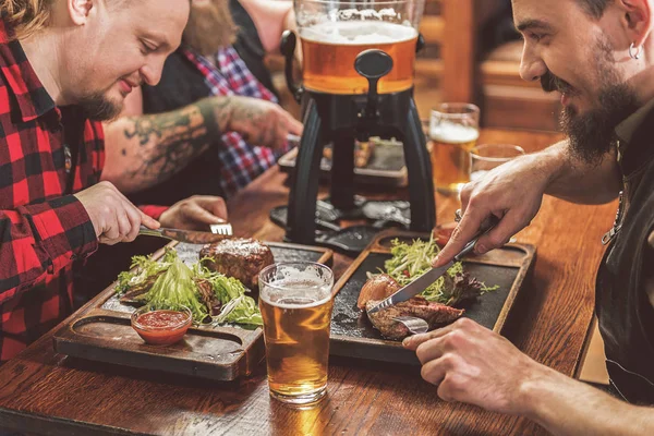 Homens alegres comendo no pub — Fotografia de Stock