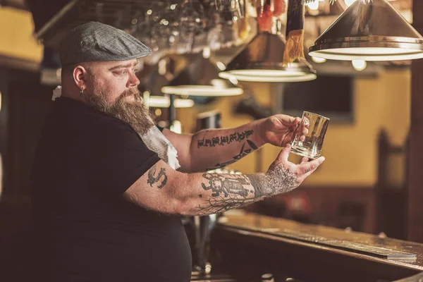 Татуированный парень ждет первого клиента в баре — стоковое фото