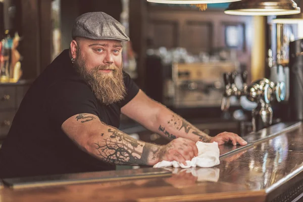 Счастливый бородатый мужчина стоит у барной стойки — стоковое фото