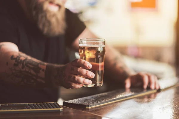 Татуированный бармен с бородой работает в пабе — стоковое фото