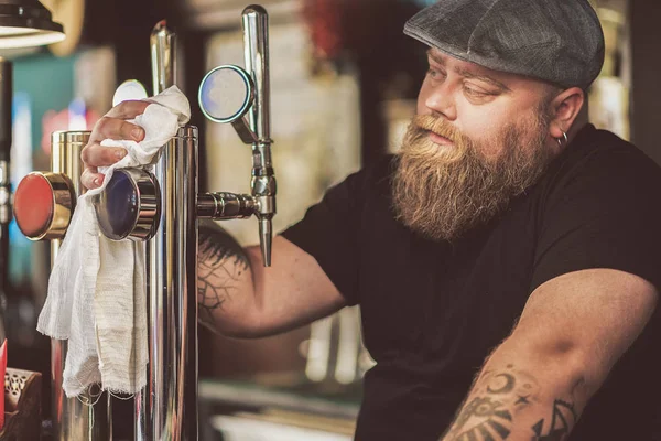 Бородатый мужчина работает барменом в пабе — стоковое фото